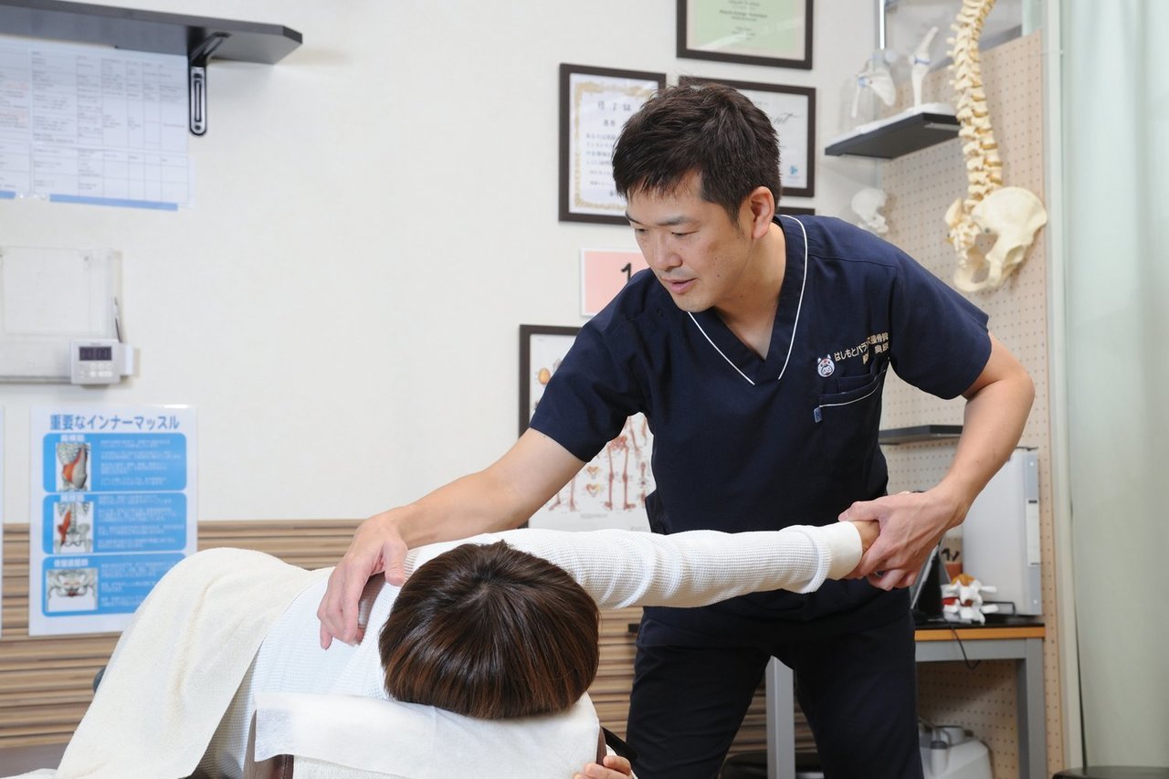 はしもとバランス整骨院院長、奥原敬が動きの改善施術を横向きの患者に行っている風景
