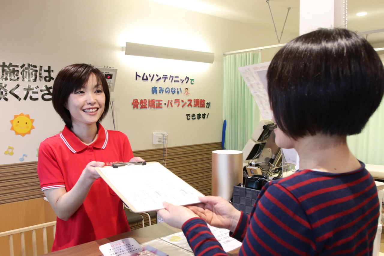 女性スタッフが常駐する受付の様子。坐骨神経痛の方も安心して来院できる体制を示す画像