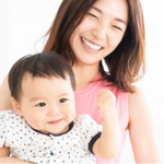 子供とほほ笑む産後の母親の画像