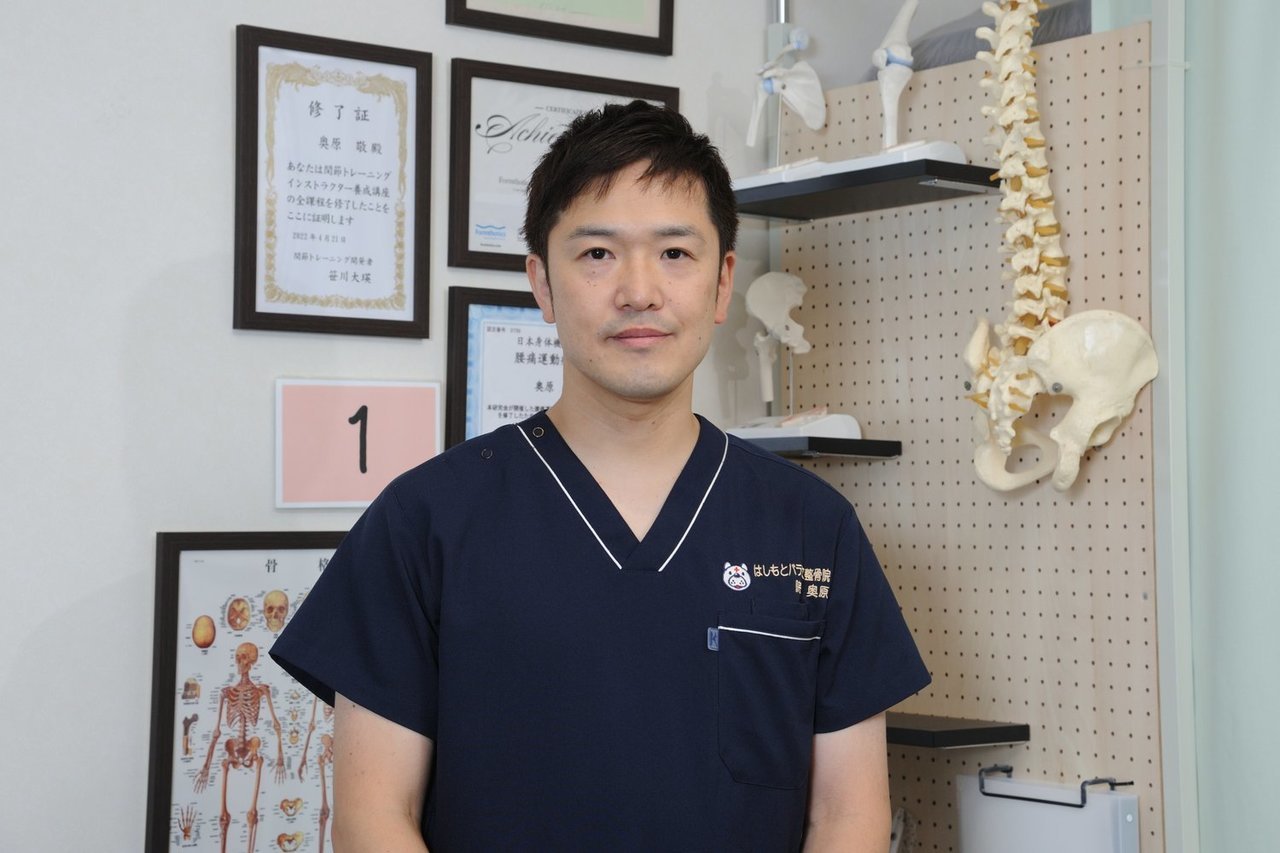 はしもとバランス整骨院 院長の奥原敬が、腰痛や椎間板ヘルニアに悩む方へ向けて想いを伝えている写真。落ち着いた表情で正面を向く院長の姿