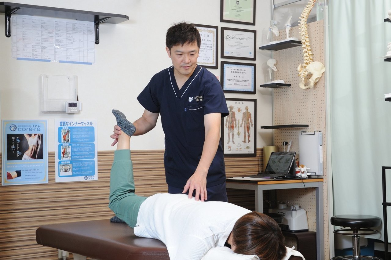 坐骨神経痛の患者に対して動き改善施術をはしもとバランス整骨院のベッドで丁寧に行う院長の様子