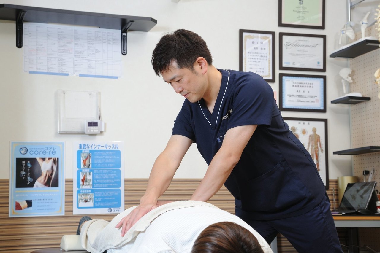 腰痛の患者に対して動き改善施術をはしもとバランス整骨院のベッドで丁寧に行う院長の様子