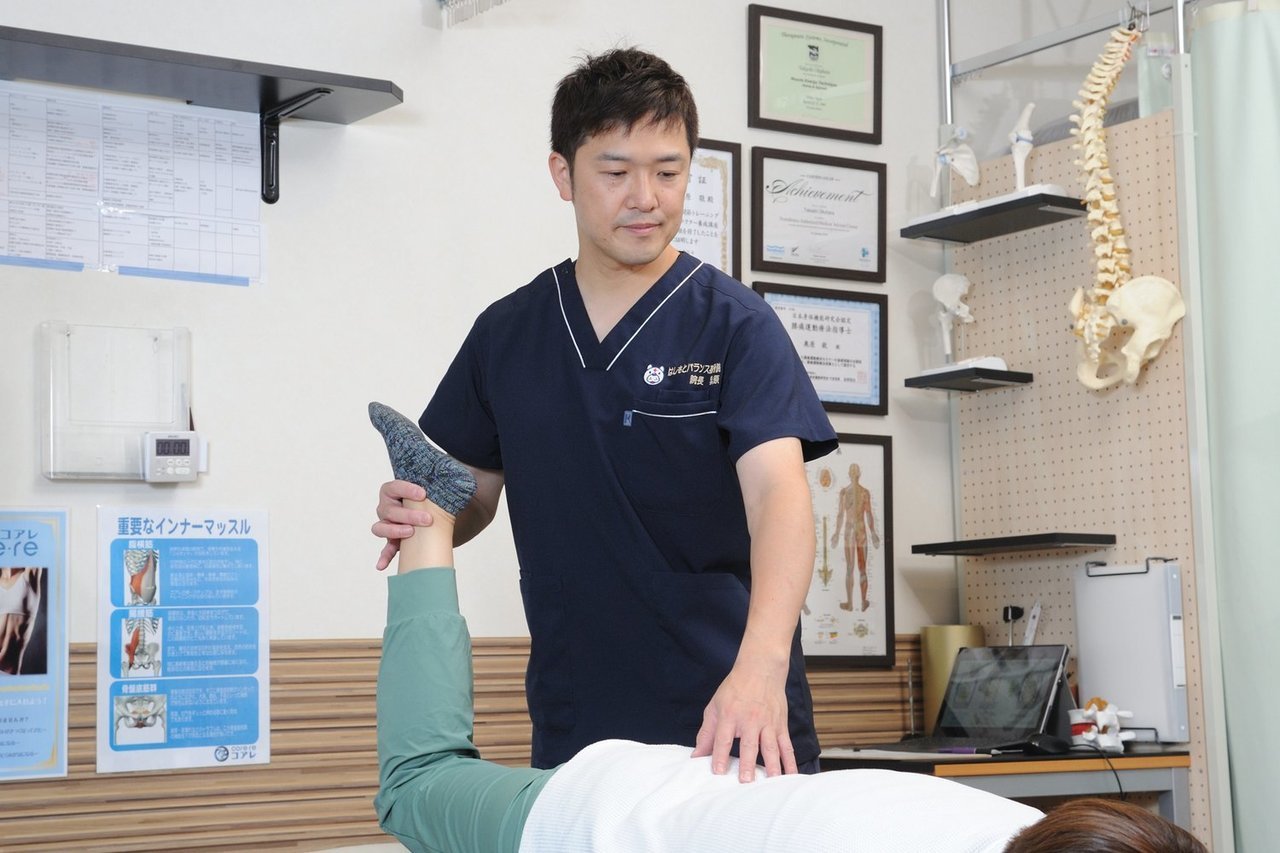 動き改善施術をはしもとバランス整骨院のベッドで丁寧に行う院長の様子